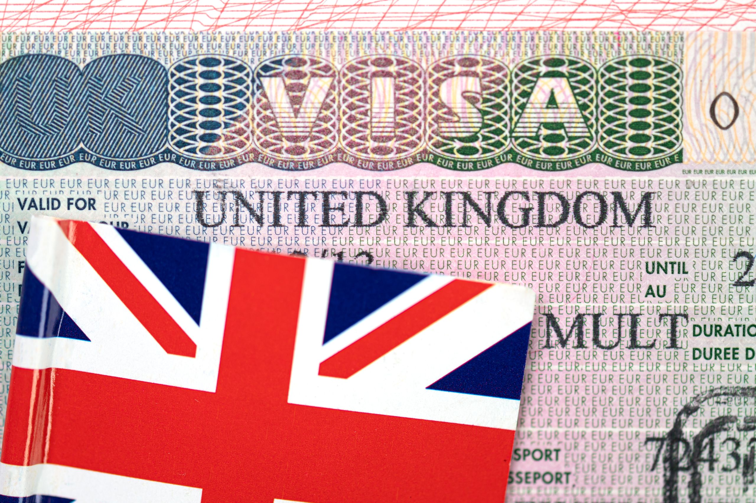 Close-up of United Kingdom visa in passport with Flag of the UK, conceptual political picture